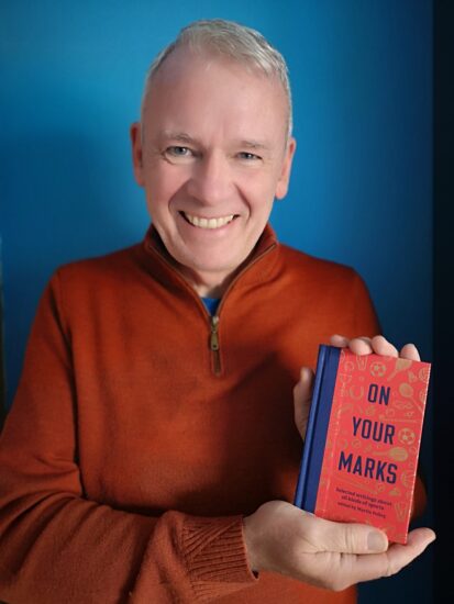 The author, Martin Polley, holding a copy of the book On Your Marks.